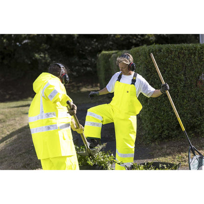 Two individuals in Guy Cotten high-visibility waterproof workwear with gardening tools in a garden agricultural setting.